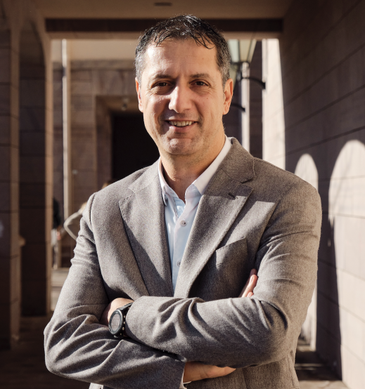 A person in a suit with his arms crossed

AI-generated content may be incorrect.